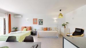 ein weißes Zimmer mit 2 Betten und einem Sofa in der Unterkunft Apartamento Studio Sao Rafael, 450m Praia in Sesmarias + 15 Fotos