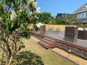 a garden with two chairs and a bench at Studio Bella in De Panne