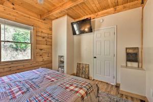 un dormitorio con una cama y una ventana en Private Mountain Creekside Cabin, with Hot Tub, en Purlear