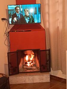 a fireplace with a tv on top of it at Suíte Buquê de Noiva in Monte Verde +14 photos