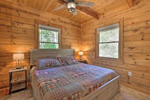 Un dormitorio con una cama en una cabaña de troncos en Private Mountain Creekside Cabin, with Hot Tub, en Purlear