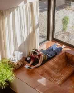 a woman laying on the floor next to a window at La Cabaña Rosa in Amealco