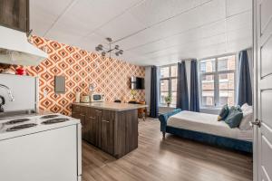 a room with a bed and a kitchen with a stove at LOFT LE RÉTRO du Centre-Ville in Quebec City