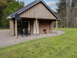 a large building with a table and chairs in it at Stone Water Cottage in Contin
