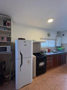 a kitchen with a white refrigerator and a stove at Belgrano Calidez Junin in Junín +2 photos