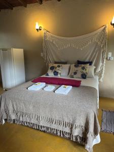 ein Schlafzimmer mit einem Bett mit zwei Handtüchern darauf in der Unterkunft Ecocentro Brasil - Bangalô 1 in São Pedro