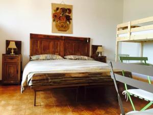 a bedroom with a large bed and a bench at La Corte del Borgo in Valverde Pavia