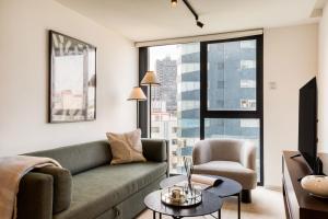 a living room with a couch and a chair at ULIV Pulse Roma - Condesa in Mexico City