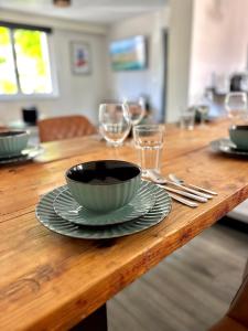 una mesa de madera con un tazón y platos y copas de vino en NBRingNest - Ferienhaus am Nürburgring in Adenau, en Adenau 16 fotos más