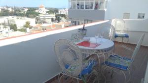 a balcony with a table and chairs on a roof at Musa Mar studio with balcony panoramic view in the residential area in Quarteira