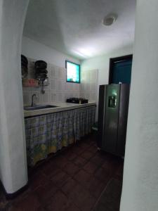 Donde Orlando - Guatiguara في سانتا مارتا: مطبخ مع ثلاجة ومغسلة ونافذة