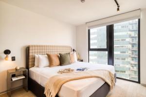 a bedroom with a large bed with a large window at ULIV Pulse Roma - Condesa in Mexico City