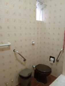 une salle de bain avec des toilettes noires et une fenêtre dans l'établissement Pousada Recanto Alto da Boa Vista, à Cachoeira Paulista 16 autres photos