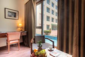 ein Hotelzimmer mit einem Schreibtisch und einem Tisch mit Obst in der Unterkunft The Sky Imperial, Jaipur in Jaipur