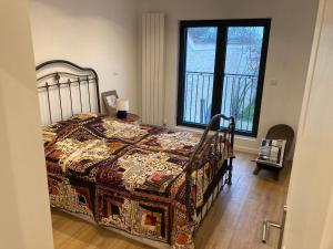 a bedroom with a bed with a blanket on it at La Maison Blanche in Dompierre-sur-Mer