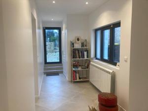 a hallway with a book shelf and a window at La Maison Blanche in Dompierre-sur-Mer
