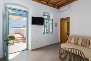a living room with a couch and a sliding glass door at Lapis Domus Milos in Plaka Milou