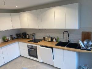 a kitchen with white cabinets and a sink at La Maison Blanche in Dompierre-sur-Mer +4 photos