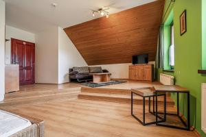 a living room with green walls and a wooden ceiling at Penzión Sobota in Poprad