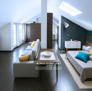 Sala de estar con 2 camas y mesa de centro en Borgo d'Oro Loft, en Bérgamo