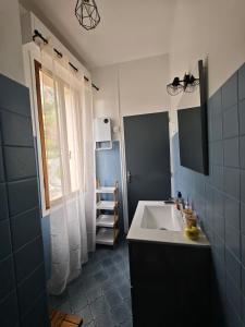 a small bathroom with a sink and a window at Studio vue sur le rocher in Moustiers-Sainte-Marie