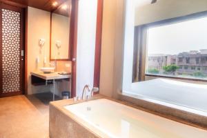 ein Badezimmer mit Badewanne und großem Fenster in der Unterkunft The Sky Imperial, Jaipur in Jaipur