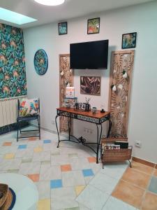 un soggiorno con scrivania e TV a schermo piatto di La Tropicale, studio climatisé avec parking, Proche Cité médiévale a Carcassonne