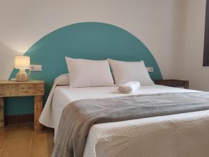 a bedroom with a large bed with a blue headboard at Apartamentos Bertrand Plaza in Lorca