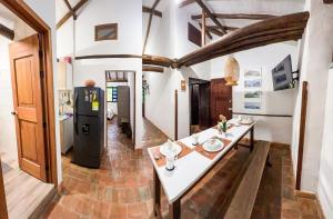a kitchen with a white table and a refrigerator at Cocoa House, Barichara in Barichara
