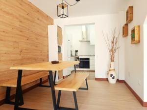 a kitchen and dining room with a wooden table and benches at Casa frente al mar en Boiro in Magdalena +34 photos