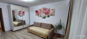 a living room with a couch and a mirror at 2 Rooms by Brancusi Central Park - Free Parking & Self Check-In in Târgu Jiu