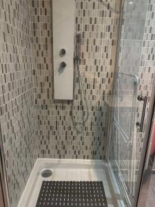 a shower with a glass door in a bathroom at L'Echappée Verte - Guînes, maison 2 chambres à 25min du Site des 2 Caps in Guînes +16 photos