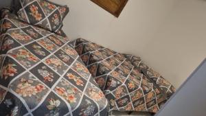 a bed with a floral patterned blanket on it at - Belezas do Monte Chalé e Suíte- La na Roça in Monte das Gameleiras