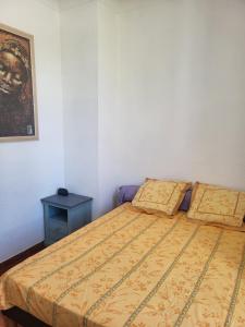 a bedroom with a bed and a side table at Appartement avec piscine partagée in Boucoiran-et-Nozières