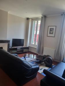 a living room with a couch and a table at Appartement avec piscine partagée in Boucoiran-et-Nozières