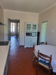 a bedroom with a large bed and a kitchen at Appartement avec piscine partagée in Boucoiran-et-Nozières