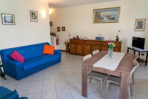 a living room with a blue couch and a table at Rosa House Varenna in Varenna
