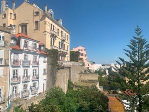 a group of buildings on a hill with a tree at The Funicularist in Lisbon