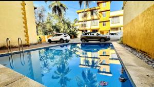 a swimming pool in a parking lot next to a building at Serenity Casa II in Goa