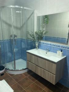 a bathroom with a sink and a glass shower at Balcón de la Plaza in Moclín +24 photos