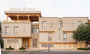 a building with a balcony on top of it at Sarhad Hotel in Bukhara
