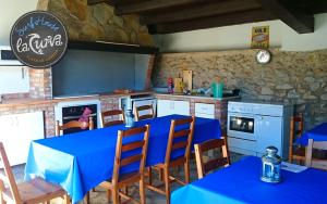 cocina con mesa azul y sillas en una habitación en La Curva Surfhouse, en Loredo