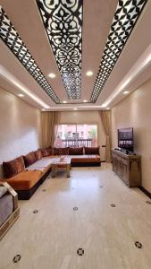 a large living room with a couch and a tv at MELBARI Central-Appart in Marrakech