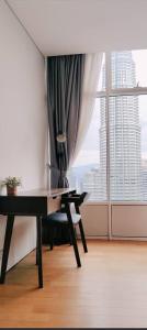 a desk and a chair in a room with a window at Sky Suites City Centre in Kuala Lumpur