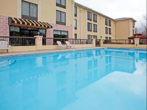 a swimming pool with two chairs and a building at Holiday Inn Express & Suites Charlotte Arpt-Belmont by IHG in Belmont
