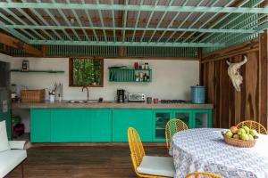 a kitchen with green cabinets and a table with a bowl of fruit at Amazing Cabin RIO LA MIEL in Estación El Salto