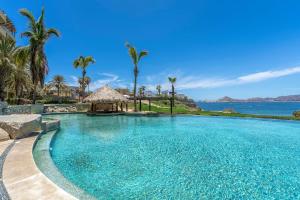 a swimming pool with a view of the ocean at Stunning 2 BR with Ocean Views & Jacuzzi by the Beach in Cabo San Lucas