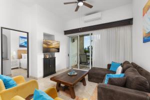 a living room with a couch and a table at Stunning 2 BR with Ocean Views & Jacuzzi by the Beach in Cabo San Lucas