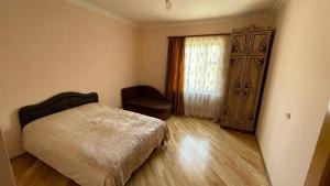 a bedroom with a bed and a window and a chair at Green garden Կանաչ այգի in Ijevan +38 photos