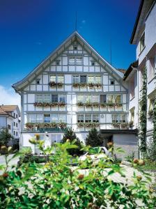 a building with potted plants in front of it at Idyllhotel Appenzellerhof in Speicher